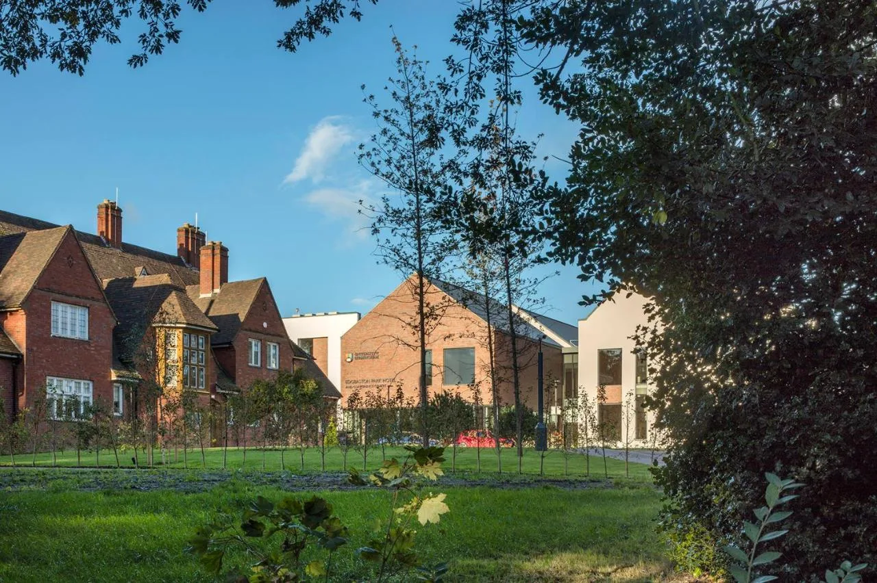 a house with a fence in front of a yard at Edgbaston Park Hotel Birmingham in Birmingham
