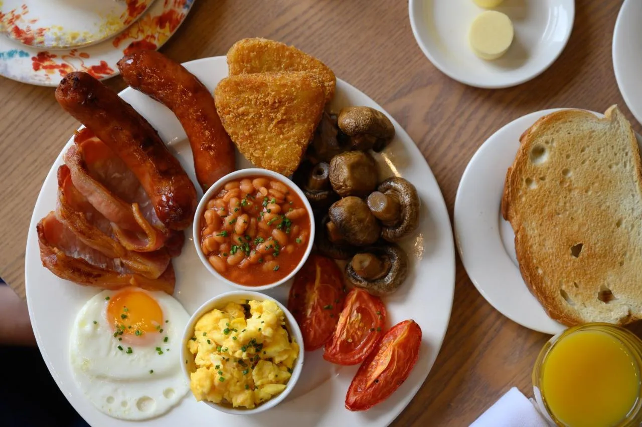 a plate of breakfast food with eggs sausage mushrooms and toast at Edgbaston Park Hotel Birmingham in Birmingham